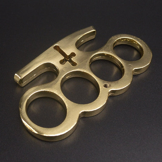Solid brass knuckle duster resting on a dark workshop bench
