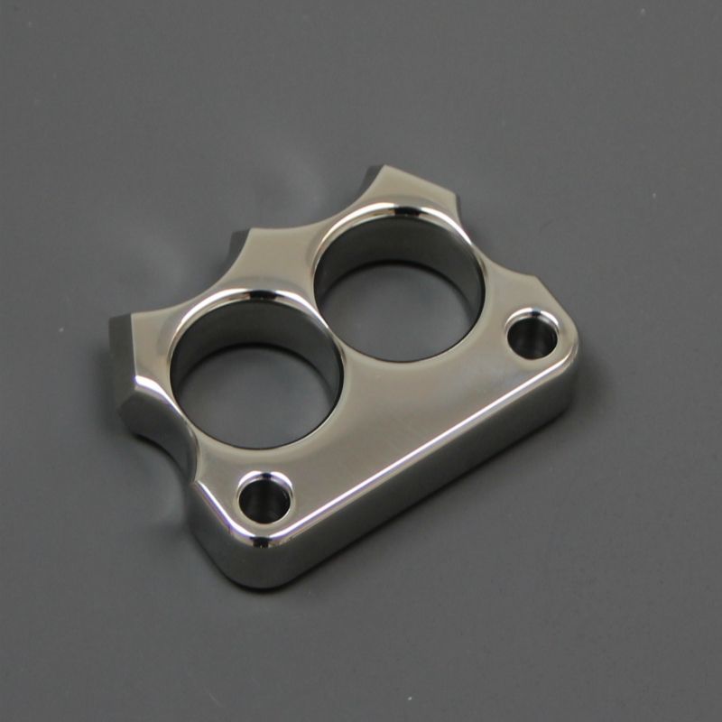 Two-finger steel knuckle duster with hardened glass-breaker tip and lanyard hole