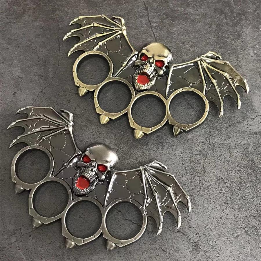 Ornate bat-winged skull knuckle duster in antique bronze and silver finishes