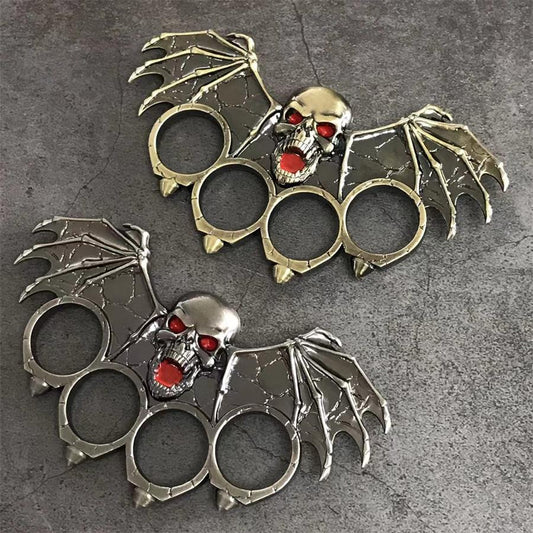 Ornate bat-winged skull knuckle duster in antique bronze and silver finishes