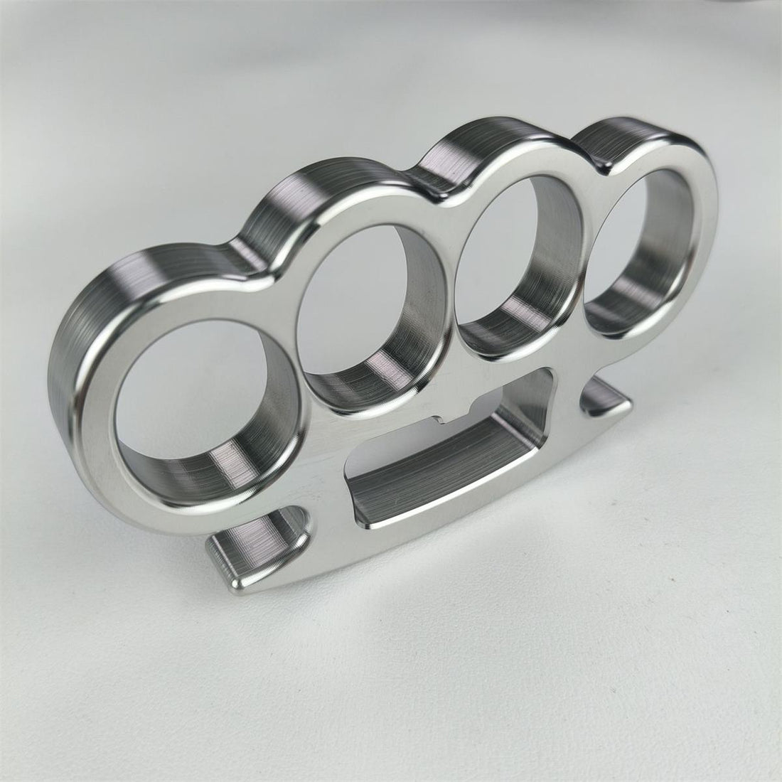 Mirror-polished stainless steel four-finger knuckle duster showing CNC machining precision