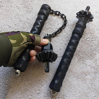 Close-up of forged steel spiked hammer head held in hand showing gear teeth and glass-breaker tip